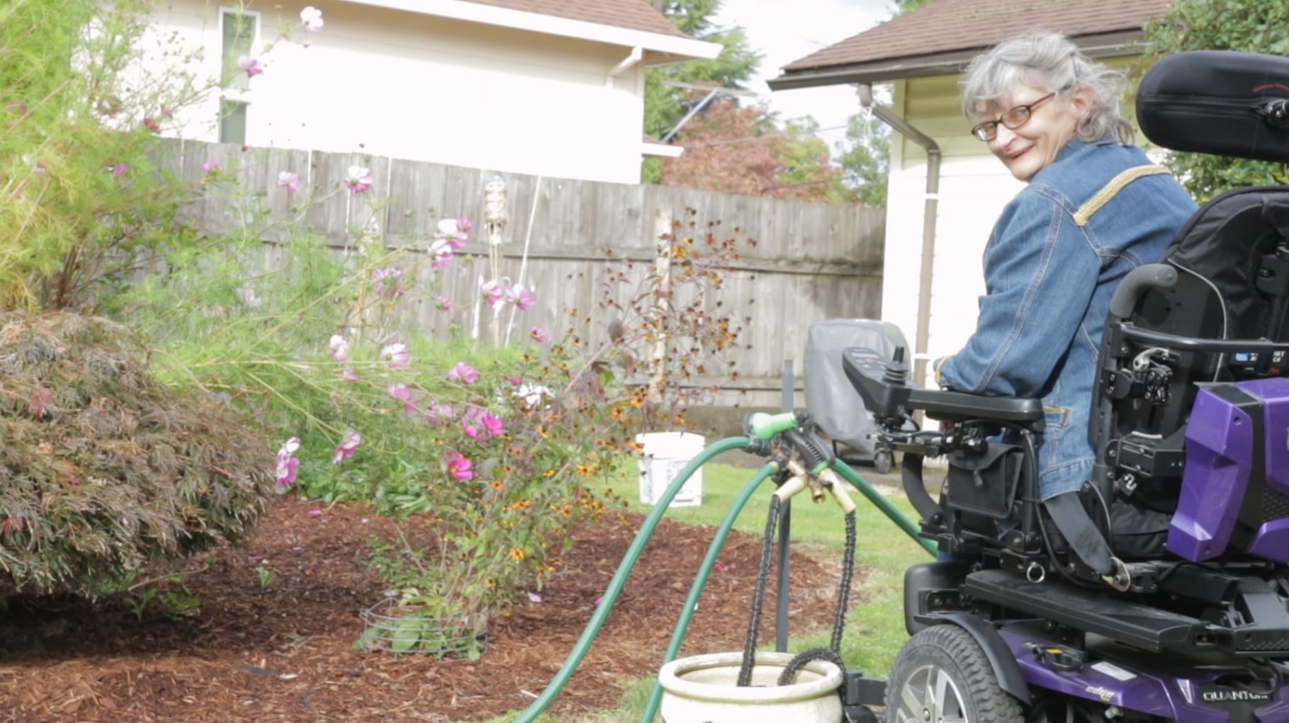 Image of woman using a wheelchair in her yard gardening